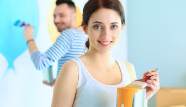 Mutlu gülümseyen genç çift boya iç cephe yeni evin portresi