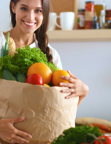 Молода жінка тримає продуктовий сумку з овочами та фруктами — стокове фото