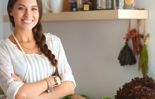 Junge Frau steht neben Schreibtisch in der Küche — Stockfoto