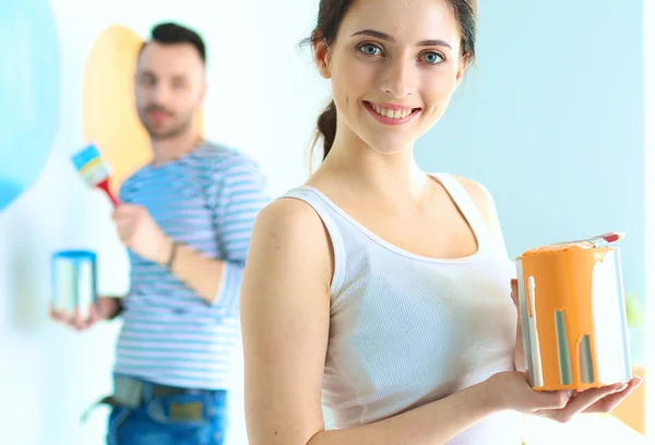 Portrait de heureux sourire jeune couple peinture mur intérieur de la maison neuve — Photo