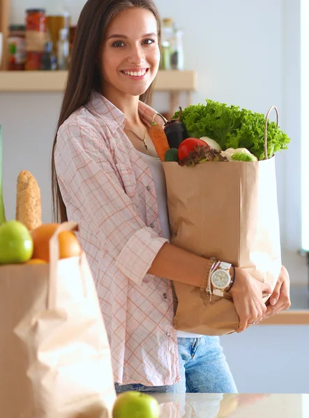 Jovem segurando supermercado saco de compras com legumes — Fotografia de Stock