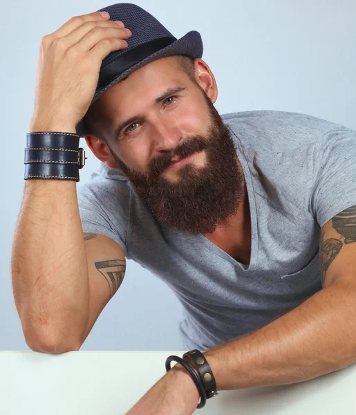 Portrait of young man in hat standing near blank, isolated on w — Stock Photo, Image