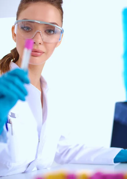 Woman researcher is surrounded by medical vials and flasks, isolated on white background — Stock Photo, Image