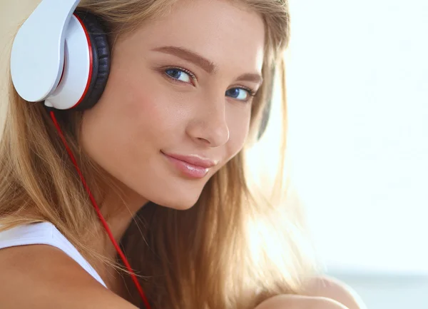 Portrait of beautiful woman in morning listening music sitting on bed at home — Stock Photo, Image