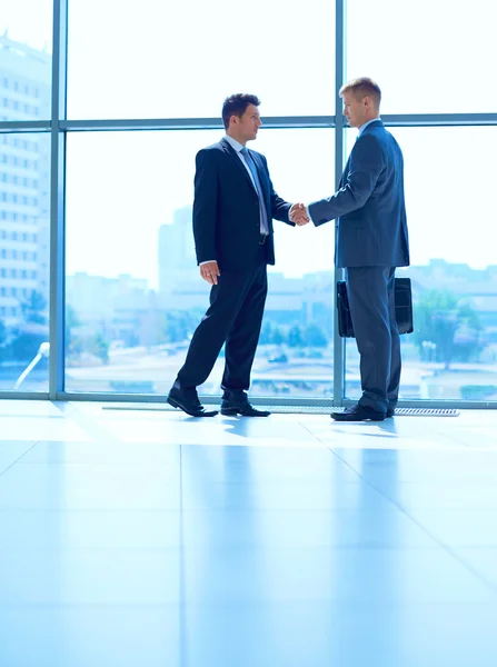 Image pleine longueur de deux hommes d'affaires qui se serrent la main Photo De Stock