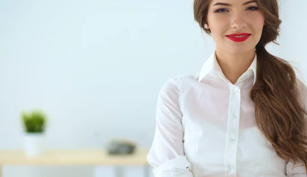 Attractive businesswoman with her arms crossed  standing in off — Stock Photo, Image