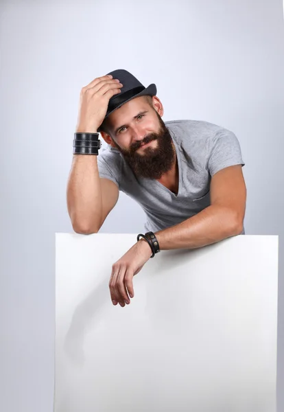 Retrato de un joven con sombrero de pie cerca del blanco, aislado sobre fondo blanco —  Fotos de Stock