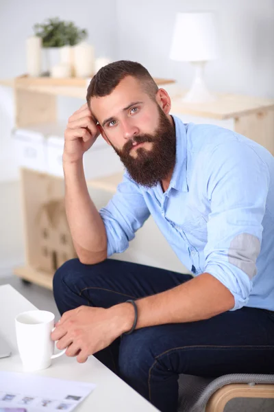 Jonge zakenman zit op stoel in functie — Stockfoto