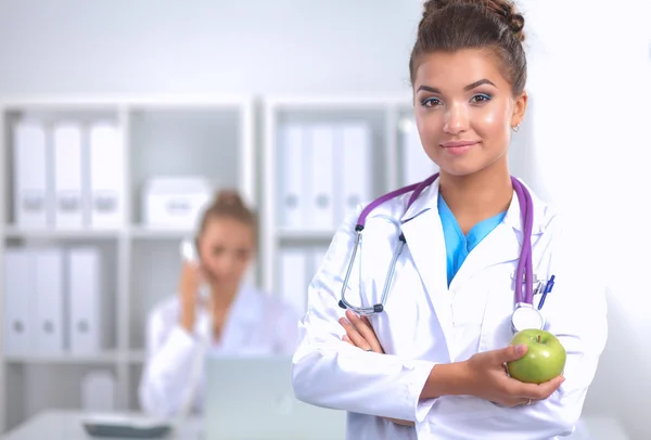 Ärztin hält einen grünen Apfel in der Hand — Stockfoto