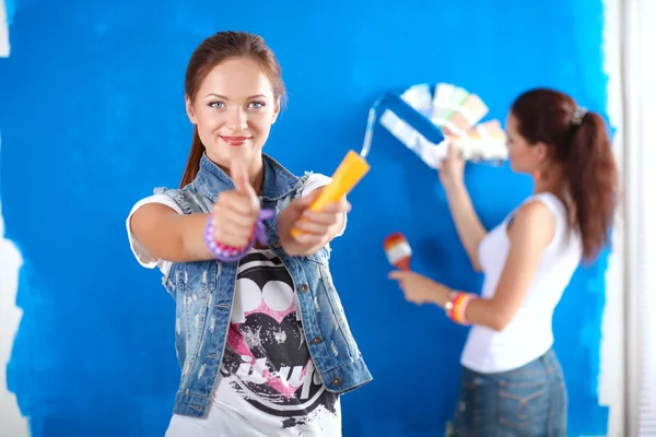 Dos mujeres hermosas jóvenes sosteniendo la paleta de colores — Foto de Stock