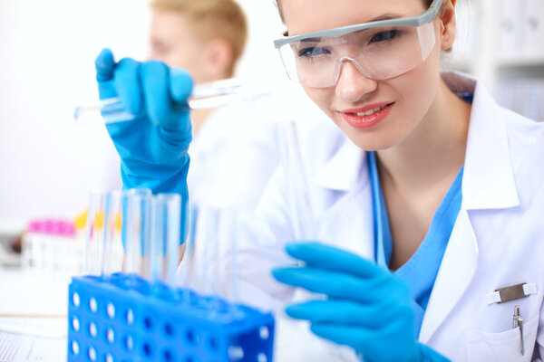 Woman researcher is surrounded by medical vials and flasks, isolated on white background