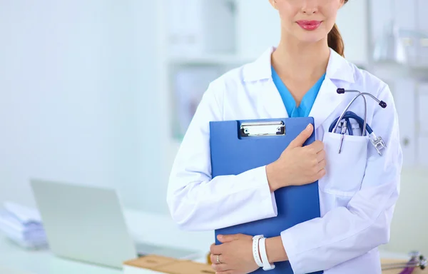 Leende kvinnlig läkare med en mapp i uniform stående vid hosp — Stockfoto