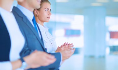 Gülümseyen iş adamları ofiste iyi bir sunumu alkışlıyorlar.