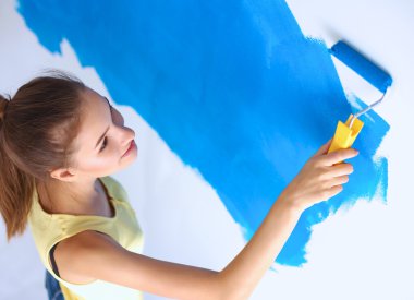 Duvar Boyama yaparken, merdiven üzerinde duran mutlu güzel genç kadın