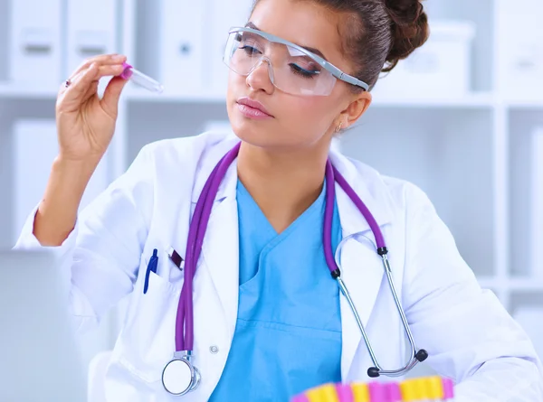 Kvindelig forsker er omgivet af medicinske hætteglas og kolber, isoleret på hvid baggrund - Stock-foto