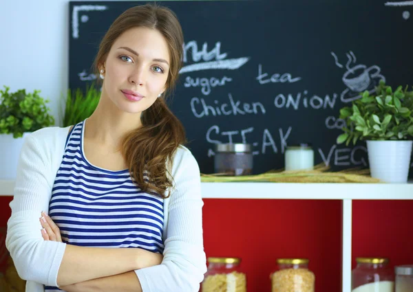 Jeune femme debout près du bureau dans la cuisine — Photo