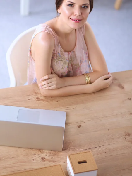 Aantrekkelijke zakenvrouw zit op het bureau in het kantoor — Stockfoto