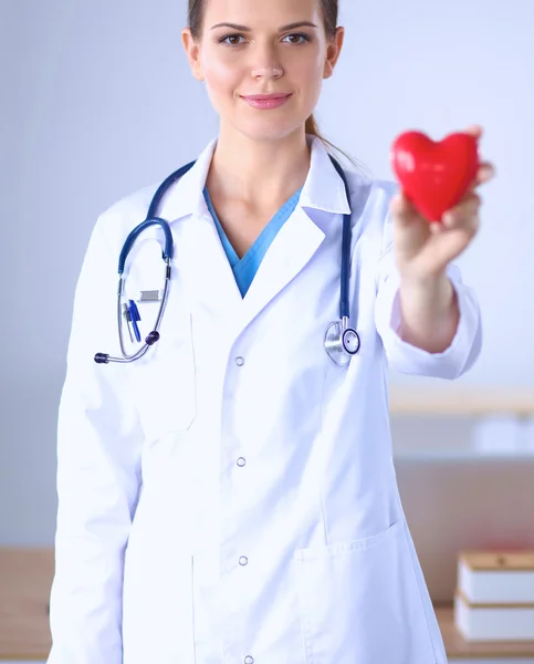 Tânăra femeie doctor care ține o inimă roșie, izolată pe fundal alb — Fotografie, imagine de stoc