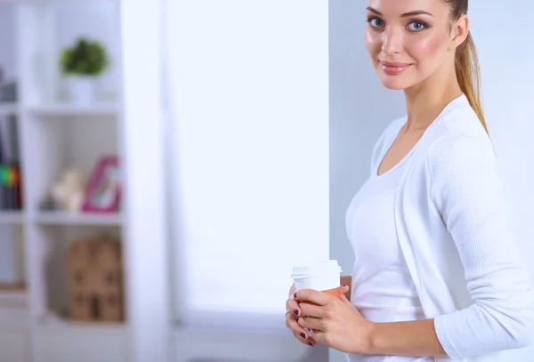 Attraktive junge Geschäftsfrau steht an Wand im Büro — Stockfoto