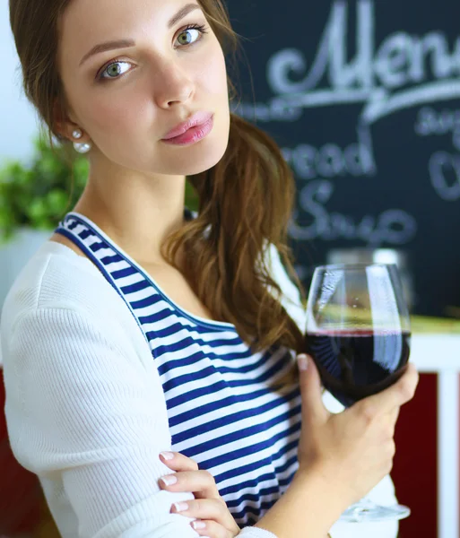 Pretty woman drinking some wine at home in kitchen Stock Picture