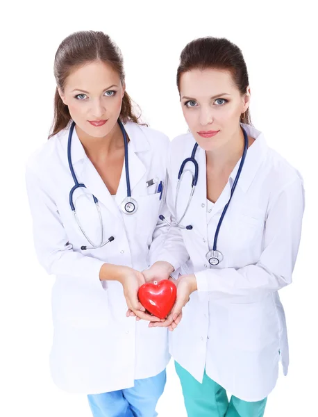 Two woman doctor holding a red heart — Stock Photo, Image