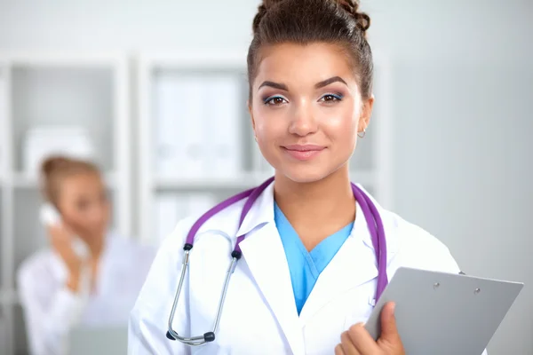 Portrait of young woman doctor with white coat standing in hospital — Stock Photo, Image