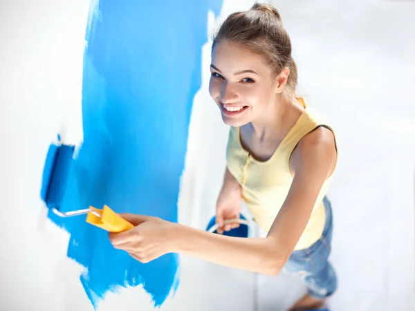 Feliz hermosa joven mujer haciendo pintura de pared — Foto de Stock