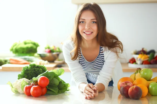 Junge Frau sitzt neben Schreibtisch in der Küche — Stockfoto