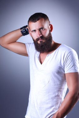 Ayakta, gri arka plan üzerinde izole yakışıklı adam portresi