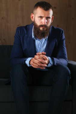 koyu arka plan üzerinde izole sofa ofis lobisinde oturan işadamı