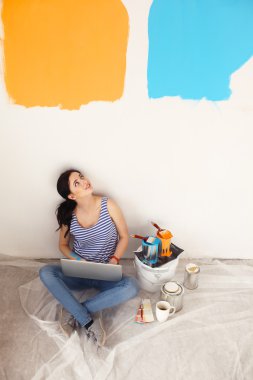 Yeni daire dizüstü bilgisayar ile oturup, boyama sırasında genç kadın portre