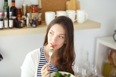 Salata yemek ve karışık salata tutan genç kadın