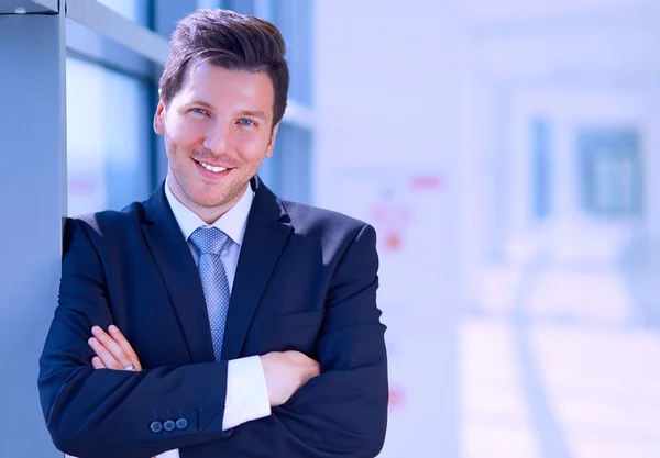 Portrait of businessman standing near window in office — Stock Photo, Image