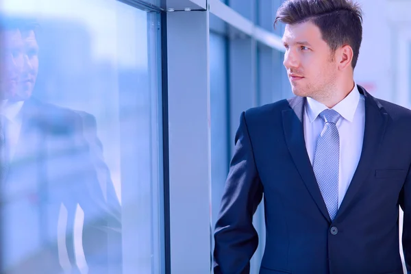 Portrait d'homme d'affaires debout près de la fenêtre dans le bureau — Photo