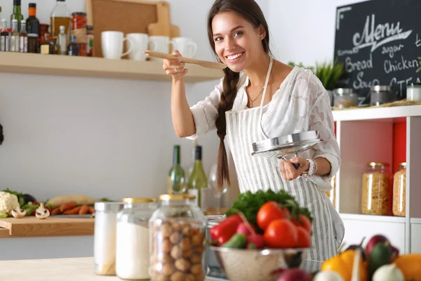 Mujer cocinera en cocina con cuchara de madera — Foto de Stock