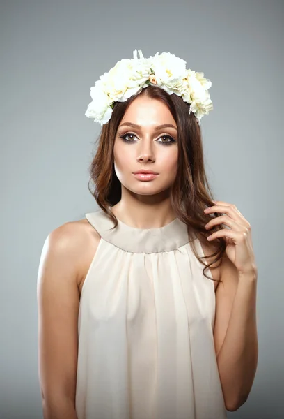 Retrato de uma mulher bonita com flores no cabelo. Moda — Fotografia de Stock