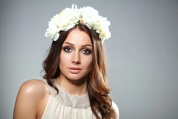 Retrato de uma mulher bonita com flores no cabelo. Moda — Fotografia de Stock