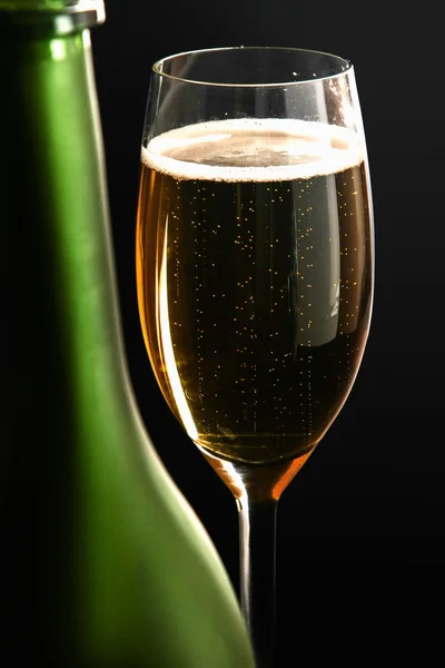 Een glas sprankelende champagne op zwarte achtergrond — Stockfoto