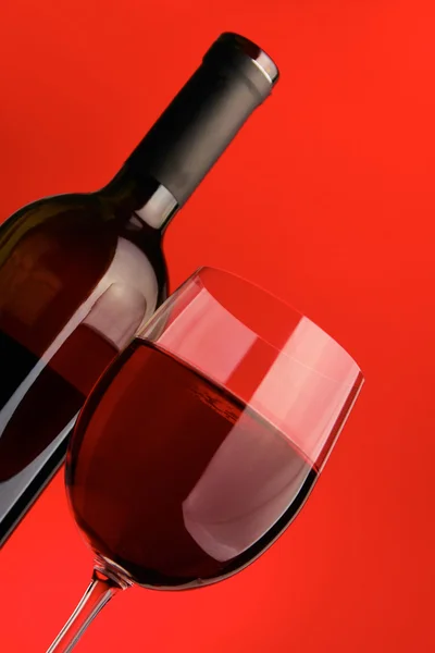 Елегантний келих для вина та пляшка вина на чорному тлі — стокове фото