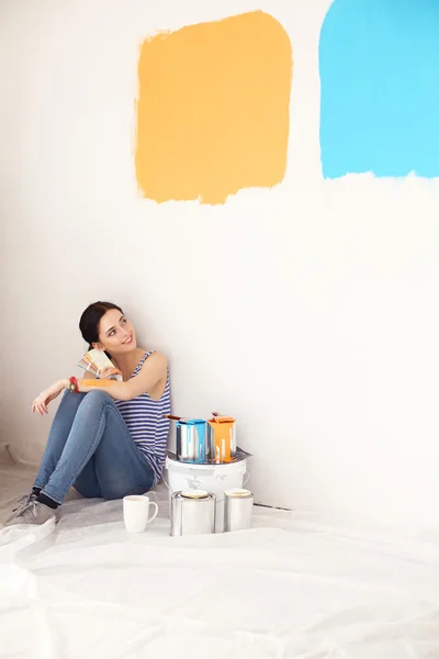 Mujer elegir el color de la pintura de la muestra para el nuevo hogar sentado en el suelo de madera — Foto de Stock