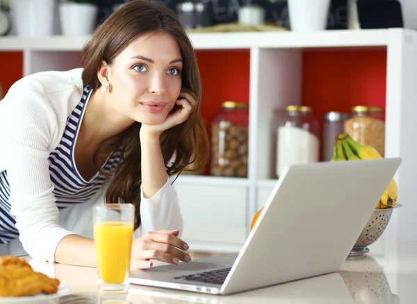 Giovane donna seduta vicino alla scrivania in cucina — Foto Stock