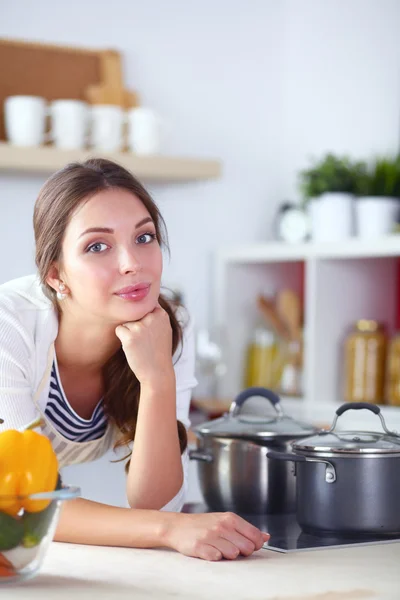 Mujer joven sentada cerca de escritorio en la cocina —  Fotos de Stock