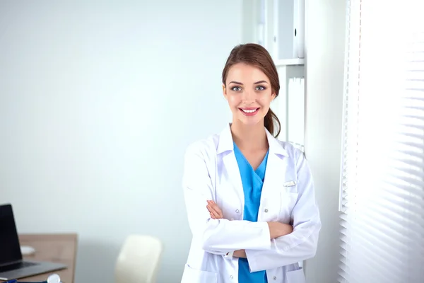 Портрет молодой женщины-врача в белом халате, стоящей в больнице — стоковое фото