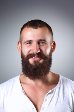 Ayakta, gri arka plan üzerinde izole yakışıklı adam portresi