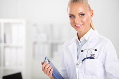 Hastanede üniformalı, gülümseyen bir kadın doktor.