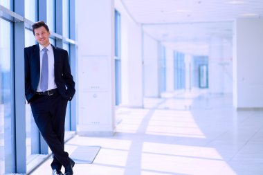 Ofisteki pencerenin yanında duran işadamının portresi