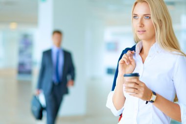 Yound kadın ayakta ofisindeki kahve içmek