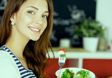 Salata yemek ve karışık salata tutan genç kadın