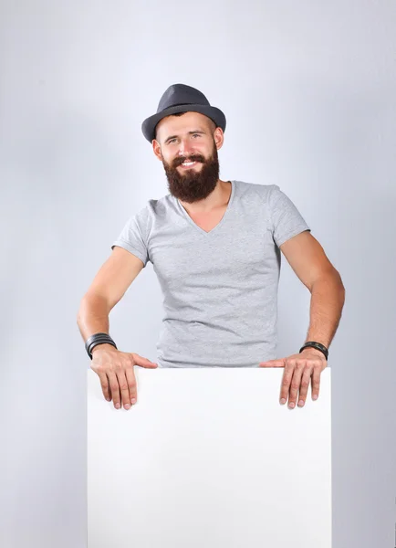 Retrato de un joven con sombrero de pie cerca del blanco, aislado sobre fondo blanco —  Fotos de Stock