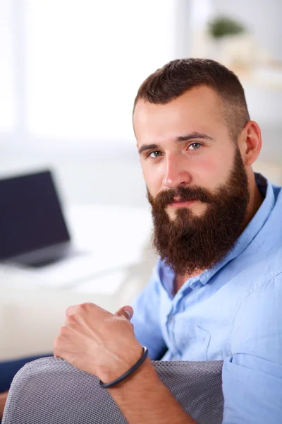 Jonge zakenman zit op stoel in functie — Stockfoto